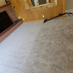 A carpet is being cleaned with a carpet cleaner, showing a distinct contrast between cleaned and uncleaned areas.